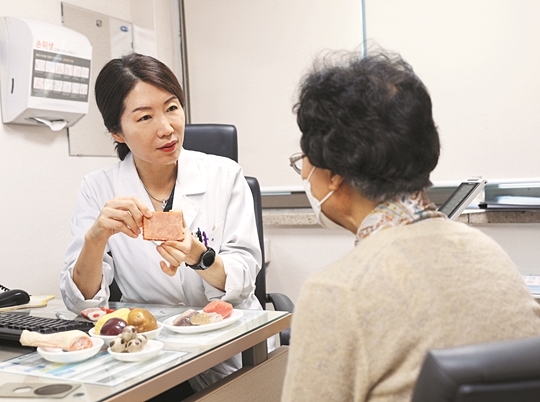 서울백병원 박현아 교수(왼쪽)가 한 노인에게 단백질 섭취와 관련한 영양 상담을 해주고 있다.