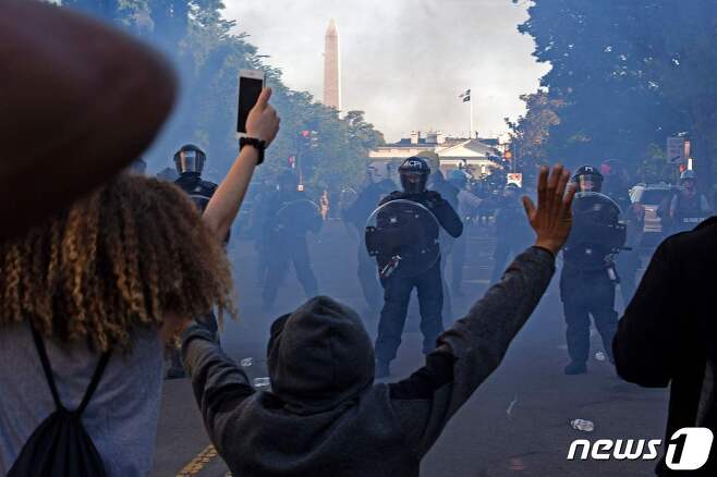 워싱턴 D.C.에서 폭동 진압 장비를 착용한 경찰들이 흑인 조지 플로이드의 죽음에 대한 항의시위대를 향해 최루탄을 발사하며 백악관 밖에서 밀어내고 있다. © AFP=뉴스1 © News1 이동원 기자