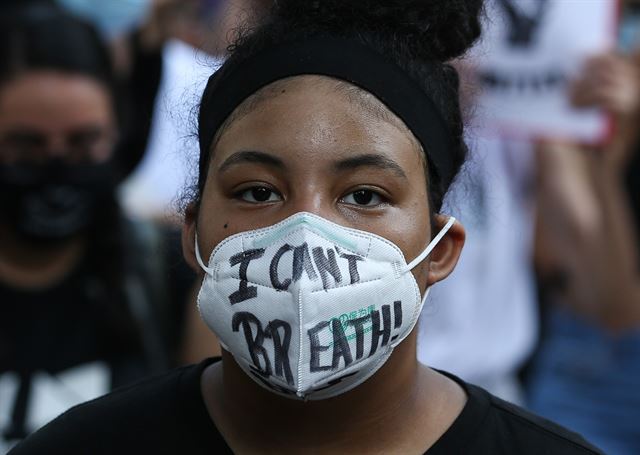 한 흑인 여학생이 “나는 숨을 쉴수 없다”는 문구가 쓰여진 마스크를 쓴 채 인종 차별 반대 시위에 참여하고 있다. 휴스턴=AP 연합뉴스