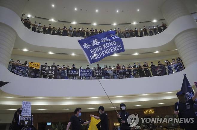 '홍콩 독립' 깃발 흔드는 시위대 (홍콩 AP=연합뉴스) 홍콩 시위대가 15일 한 쇼핑몰에서 '범죄인 인도 법안'(송환법) 반대 시위 1주년을 맞아 당시 추락해 숨진 남성을 추모하면서 '홍콩 독립'이라고 쓰인 깃발을 흔들고 있다. sungok@yna.co.kr