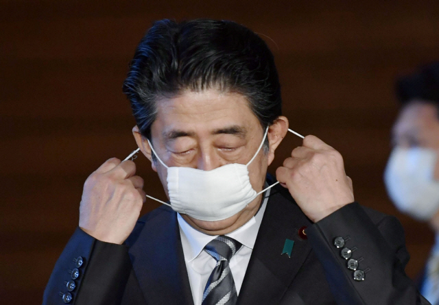 아베 신조 일본 총리가 지난달 1일 도쿄 총리 관저에서 코로나19 관련 기자회견 도중 마스크를 벗고 있다./로이터연합뉴스