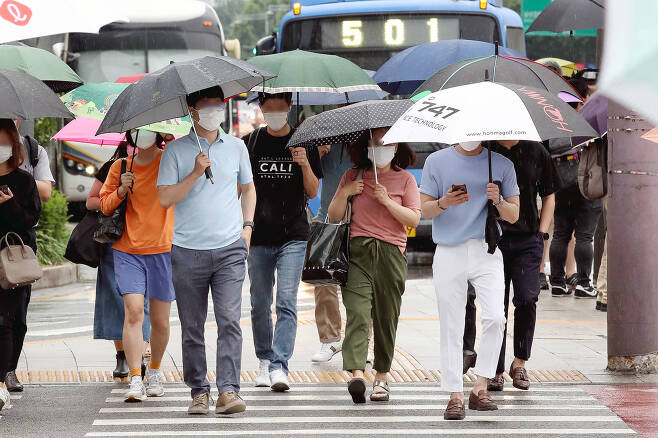 본격적으로 장마가 시작되는 24일 서울 종로구 광화문 네거리에서 시민들이 우산을 쓰고 출근하고 있다. 뉴시스