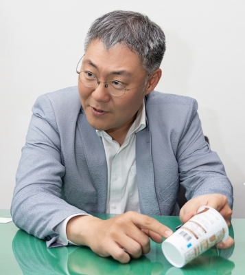 조흥로 SR테크노팩 대표가 자체 개발한 소재 GB-8이 적용된 플라스틱 연포장재가 적용된 컵커피를 소개하고 있다/사진=SR테크노팩