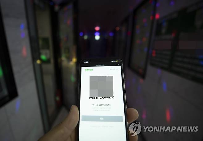 노래방도 QR코드로 출입 (서울=연합뉴스) 노래연습장과 클럽, 헌팅포차 등 감염병 전파 위험이 큰 고위험시설 출입에 전자출입명부 시스템이 의무화된 10일 오후 서울의 한 노래방에서 취재진이 QR코드를 들어보이고 있다. 2020.6.10 photo@yna.co.kr
