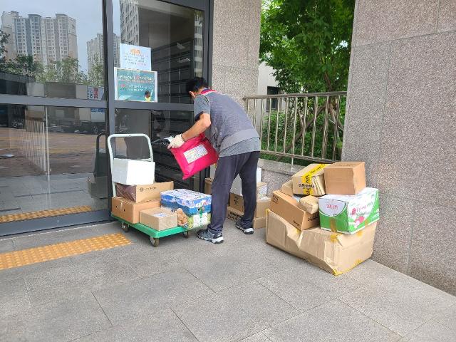 택배기사가 2일 남양주 다산신도시 아파트 입구에서 손수레로 옮긴 택배물품을 내려 놓고 있다. 이종구기자