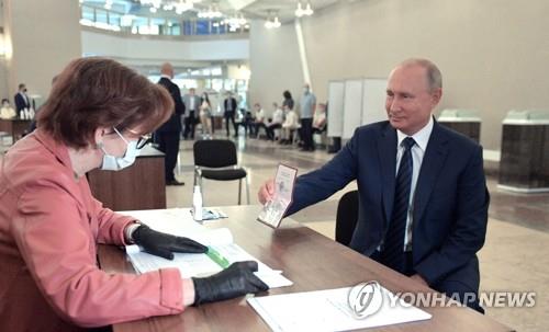 (모스크바 EPA=연합뉴스) 블라디미르 푸틴 러시아 대통령이 1일(현지시간) 모스크바의 한 투표소에서 개헌안 국민투표에 참여하기 위해 개인 여권을 제시하고 있다.