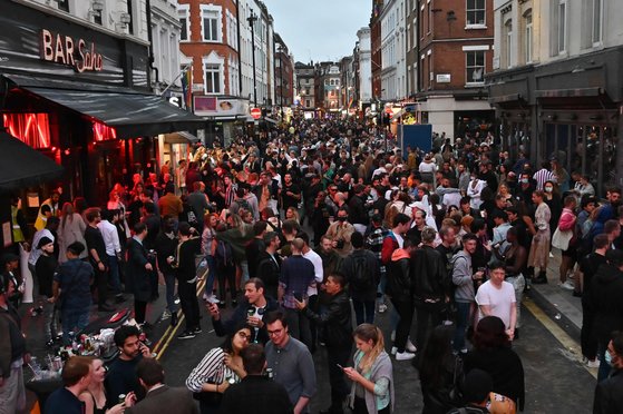 7월 4일 영국 런던 시내 거리가 사람들로 가득 찼다. 코로나19로 문을 닫았던 술집과 식당들이 3개월 만에 다시 문을 열자 인파가 몰렸지만 마스크를 쓴 사람은 보이지 않았다. [AFP=연합뉴스]