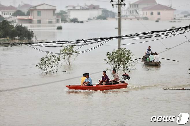 15일 (현지시간) 중국 최대 담수호인 포양호 인근 장시성 주장의 주민들이 폭우로 물에 잠긴 마을에서 보트를 타고 이동하고 있다. © AFP=뉴스1 © News1 우동명 기자