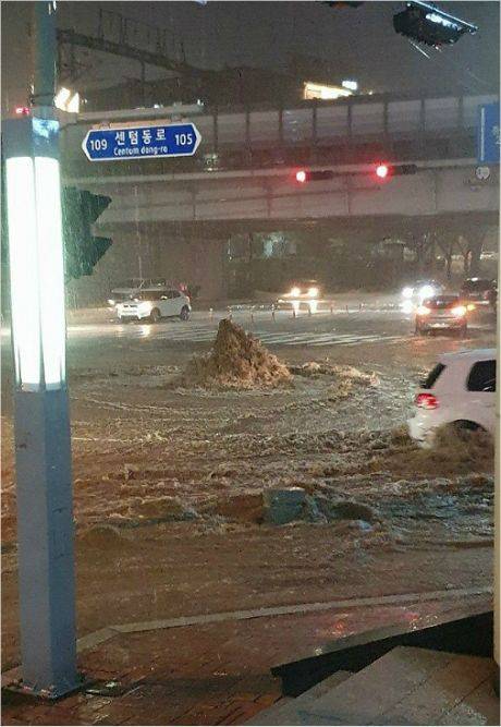 23일 오후 부산에 비가 쏟아지면서 해운대구 우동 한 교차로 하수관이 역류하고 있다. (사진=부산경찰청 제공)