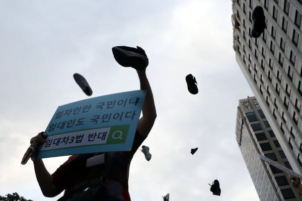 정부의 고강도 부동산 규제에 반발하는 시민들이 25일 저녁 서울 중구 예금보험공사 앞에서 열린 '부동산 규제정책 반대, 조세저항 촛불집회’에서 신발을 던지는 퍼포먼스를 하고 있다. 사진=뉴스1