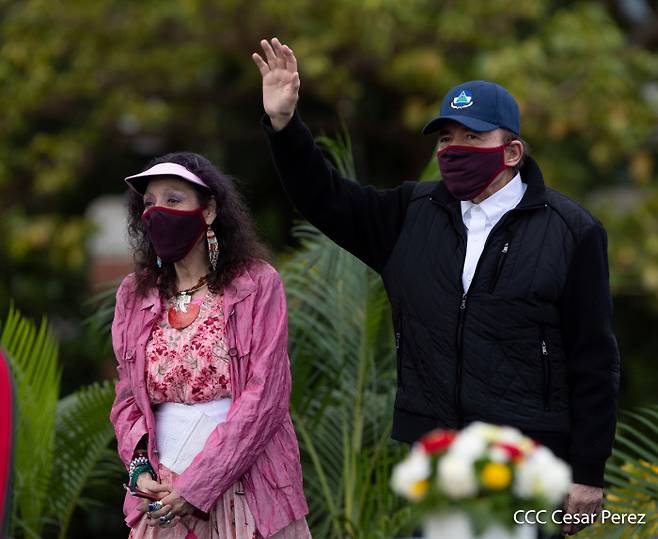 지난 19일(현지시간) 다니엘 오르테가 니카라과 대통령(오른쪽)과 부통령이자 아내인 로사리오 무리요가 수도 마나과에서 열린 ‘산디니스타 해방’ 41주년 기념행사에 참여해 인사하고 있다. 이날 오르테가 대통령은 처음으로 공식석상에서 마스크를 썼다.   마나과 ｜로이터연합뉴스