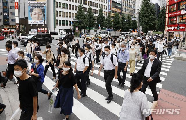 [도쿄=AP/뉴시스]지난 29일 일본 도쿄의 한 횡단보도를 신종 코로나바이러스 감염증(코로나19) 예방을 위해 마스크를 쓴 시민들이 건너고 있다. 2020.07.30.