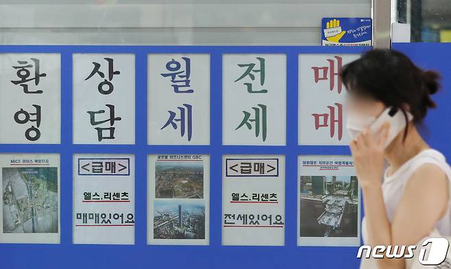 정부가 '8.4 주택공급대책'을 통해 서울 재건축·재개발 관련 규제를 조건부로 완화하기로 결정하면서 강남권 정비사업 추진에 대한 기대감이 높아지고 있는 가운데 4일 오후 송파구의 한 부동산 앞으로 한 시민이 지나가고 있다. 2020.8.4/뉴스1 © News1 이성철 기자