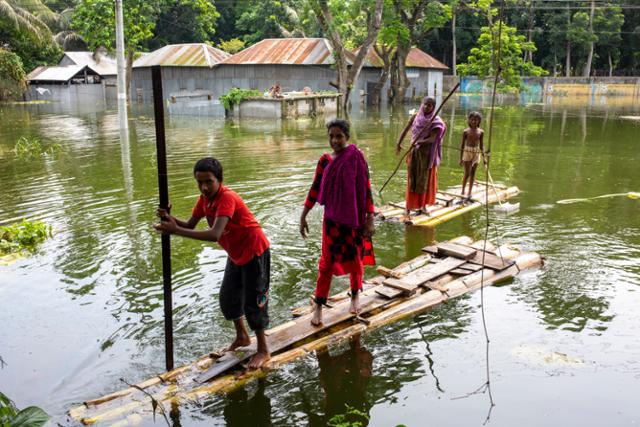 방글라데시가 몬순폭우로 국토의 3분의 1이 침수된 가운데 지난달 25일 수도 다카의 도하르에서 수재민들이 바나나 뗏목을 타고 이동하고 있다. 도하르=EPA 연합뉴스