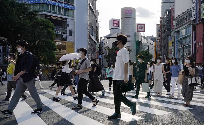 마스크를 착용한 일본 젊은이들이 도쿄 번화가인 시부야의 교차로 횡단보도를 건너가고 있다. [연합]