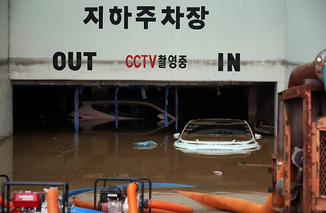 9일 오전 광주 북구 신안동 한 아파트에서 전날 집중호우로 신안교가 범람하며 침수된 지하주차장의 배수 작업이 이틀째 이루어지는 가운데 물에 잠긴 일부 차량이 보인다. 연합뉴스