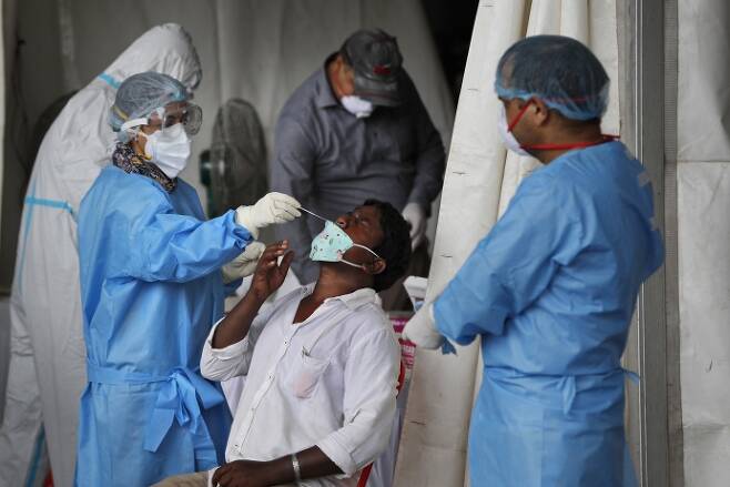 지난 18일(현지시간) 인도 뉴델리에서 보건당국 직원들이 코로나19 검사를 진행하고 있다. 뉴델리 | AP연합뉴스