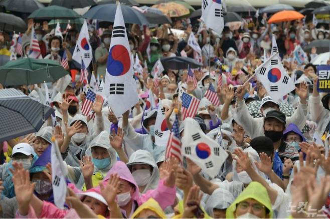 지난 15일 오후 서울 종로구 동화면세점 앞에서 열린 보수단체의 광복절 집회에서 참서자들이 태극기와 성조기를 흔들고 있다.(사진=이한형 기자)