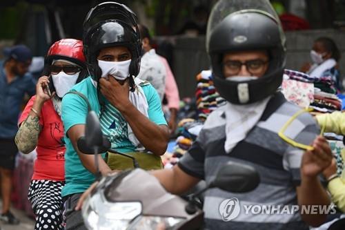 인도 뉴델리에서 마스크를 쓰고 오토바이를 탄 주민. [AFP=연합뉴스]