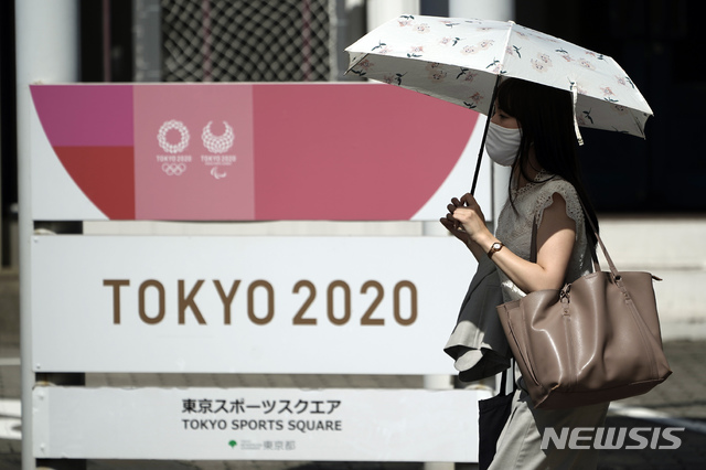 [도쿄=AP/뉴시스] 4일(현지시간) 일본 도쿄에서 한 여성이 신종 코로나바이러스 감염증(코로나19)을 막기 위해 마스크를 쓴 채 도쿄 올림픽 광고판 앞을 지나가고 있다. 2020.09.04.