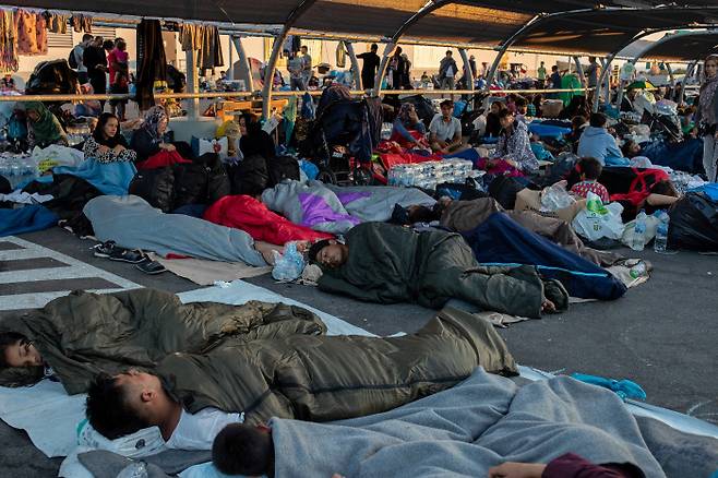 11일(현지시간) 그리스 레스보스섬의 모리아 난민캠프 인근 도로 위에서 난민들이 잠들어 있다. 레스보스｜로이터연합뉴스