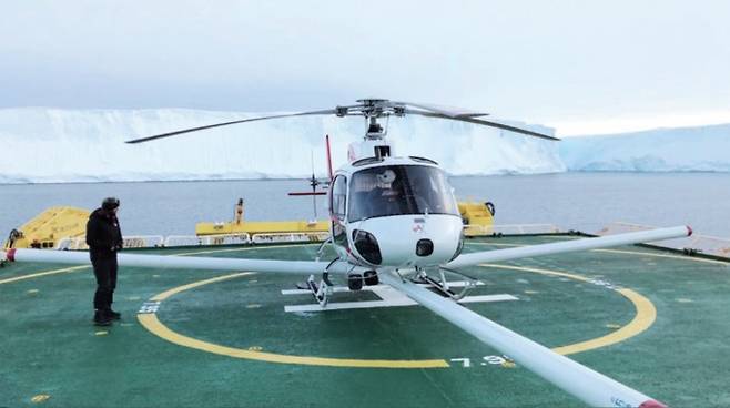 서남극 아문센해에 정박한 아라온호에서 스웨이츠 빙하로 이동하기 위해 준비 중인 헬리콥터. 뒤에 보이는 흰 절벽이 스웨이츠 빙하다. 아리랑 5호의 영상레이더를 활용하면 사전에 빙하 밑 지형을 확인할 수 있다. 극지연구소 위성탐사·빙권정보센터 제공