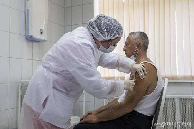 [모스크바=AP/뉴시스]15일(현지시간) 러시아 모스크바에서 한 지원자가 실험용 스푸트니크 V 코로나바이러스 백신을 맞고 있다. 러시아 보건 당국은 위약 조절(placebo-control)이 가능한 4만 명의 무작위 지원자들을 대상으로 이 백신에 대한 시험에 착수했다고 밝혔다. 러시아의 코로나19 누적 확진자 수는 107만3849명, 사망자는 1만8785명으로 집계됐다. 2020.09.16.