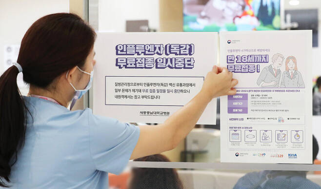 22일 오전 세종시에 있는 한 대형병원에서 인플루엔자(독감) 백신 무료접종 연기 안내문을 붙이고 있다. 연합뉴스