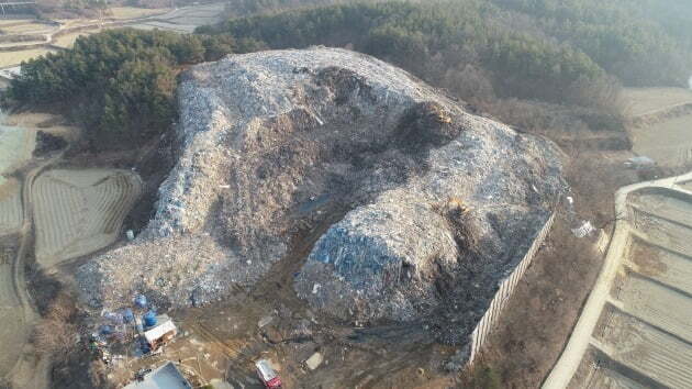 2019년 1월 경북 의성군 단일면 ‘쓰레기산’ 현장 사진. 축구경기장 2배 면적, 3층 건물 높이로 19만2000톤에 달하는 폐기물 때문에 작업하는 굴삭기도 알아보기도 힘들 정도다. 의성군 제공