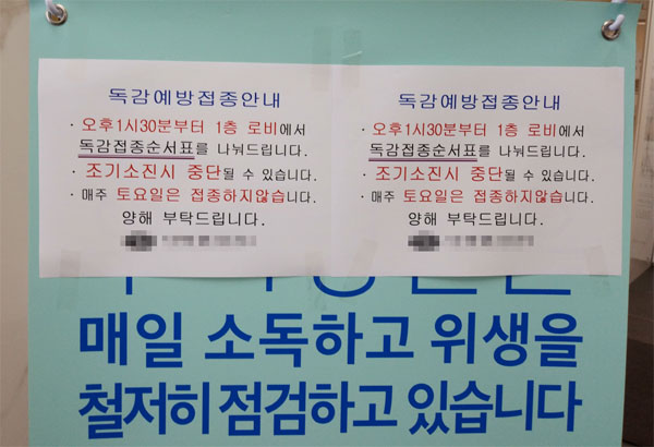 유료 독감백신을 접종하려는 사람들이 몰리면서  24일 서울 은평구의 한 내과 의원이 접종 순서 번호표를 부여한다는 안내문을 붙였다.  [서진우 기자]