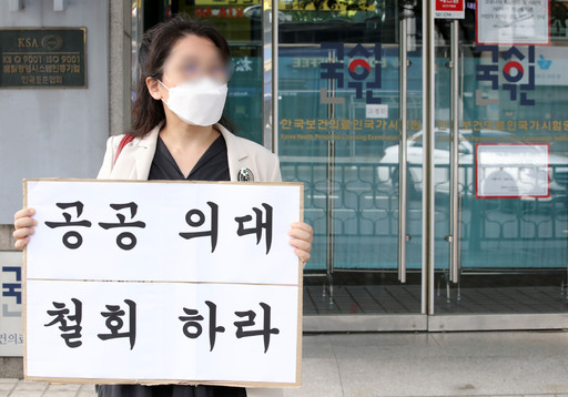 지난 10일 오후 한 전공의가 서울 광진구 한국보건의료인국가시험원 본관 앞에서 공공의대 정책 철회를 요구하는 1인 시위를 하고 있다. 정부는 의과대학생들이 의사 국가시험을 스스로 거부하고 있는 상황에서 추가 시험 등은 가능하지 않다는 입장이다. 뉴시스