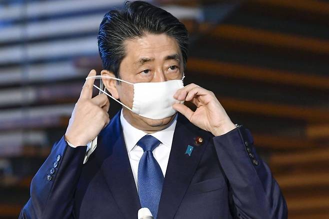 아베 신조 전 일본 총리가 지난 4월 도쿄 총리 관저에서 기자회견을 하면서 마스크를 벗고 있다./사진=[도쿄=AP/뉴시스]