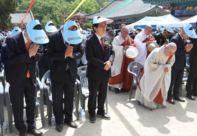 자유한국당 황교안 전 대표가 2019년 5월 12일 경북 영천 은해사를 찾아 부처님오신날 봉축 법요식에 참석하고 있다. 다른 참석자들이 합장한 후 반배를 올리는 있는 동안 합장을 하지 않고 두 손을 아래로 모으고 있다. / 연합뉴스