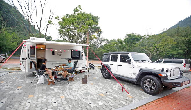 자동차야영장 카라반 사이트에서 캠핑을 즐기는 가족의 모습