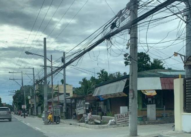 필리핀서 확장한 차로 중간에 서 있는 전봇대들 [인콰이어러 웹사이트 캡처. 재판매 및 DB 금지]