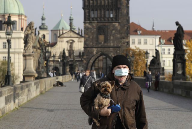 체코 프라하에서 21일(현지시간) 마스크를 쓴 시민이 반려견을 안고 카를교 위를 걷고 있다.  AP 연합뉴스
