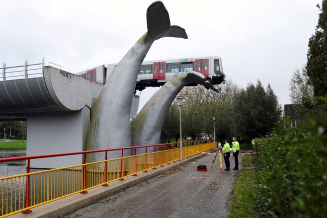 네덜란드 로테르담시 스파이크니스의  드 애커스역에서 2일(현지 시각) 열차가 '고래 꼬리' 조각품 위에 매달려있다. /로이터 연합뉴스