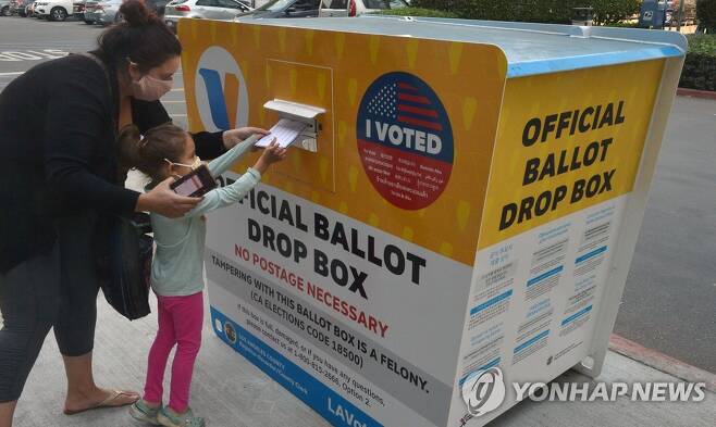 지난달 26일(현지시간) 미국 캘리포니아주 로스앤젤레스에서 한 소녀가 모친의 투표용지를 USPS 우편함에 넣고 있다.  [UPI=연합뉴스]