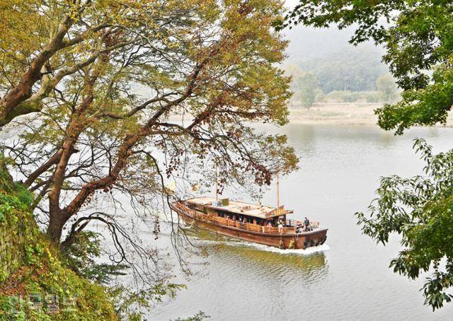 고란사 아래 백마강으로 황포돛배 유람선이 지나가고 있다.
