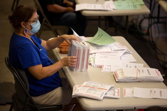 미국 대선을 하루 앞둔 지난 2일캘리포니아주 산타아나에 있는 오렌지카운티 유권자 등록센터에서 한 선거관리요원이 우편투표 용지를 분류하고 있다. 산타아나=로이터 연합뉴스