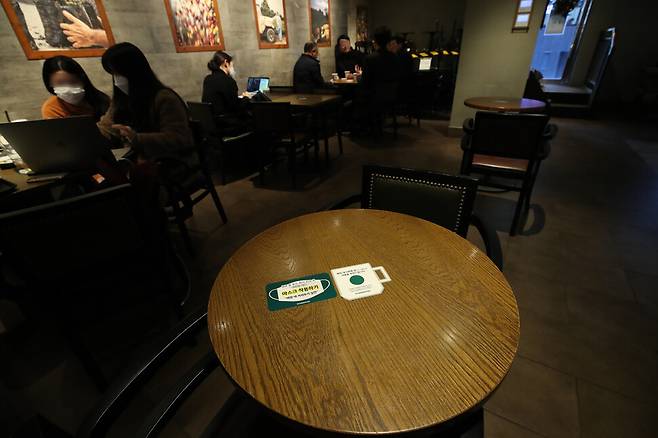 23일 낮 서울 시내 한 프렌차이즈 카페 탁자 위에 마스크 착용을 안내하는 스티커가 붙어 있다. 백소아 기자