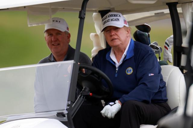 도널드 트럼프 미국 대통령이 22일 버지니아주 스털링 트럼프 내셔널 골프클럽'서 골프 카트를 몰고 있다. 스털링=로이터 연합뉴스