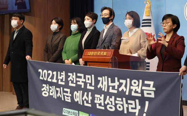 용혜인(오른쪽 두 번째) 기본소득당 의원과 녹색당, 미래당, 여성의당 관계자들이 4일 국회 소통관에서 2021년 보편적 재난지원금 정례지급 에산 편성을 촉구하는 기자회견을 하고 있다. 오대근 기자