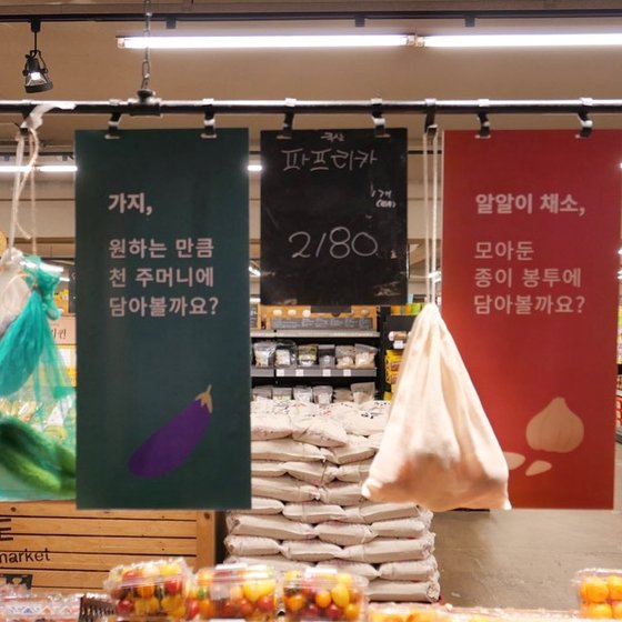 서울 서대문구 연희동 '사러가 마트'의 농산물 매대. 천주머니와 종이 등에 포장할 것을 제안하는 문구가 쓰여있다. 사진 유어보틀위크