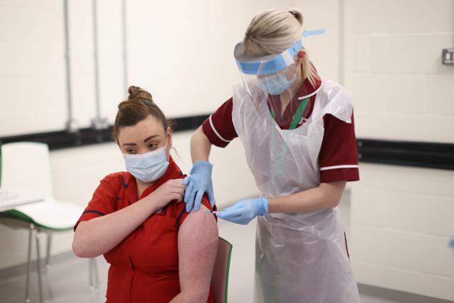 영국에서 화이자·바이오엔테크 백신 접종이 시작된 8일 북아일랜드 벨파스트의 첫 백신 접종자인 수간호사 조안나 슬론이 주사를 맞고 있다. 벨파스트=EPA 연합뉴스