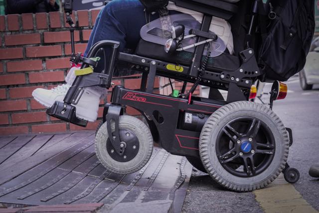 지난 2일 서울 종로구 혜화동 일대에 설치된 경사로 위에서 문씨의 휠체어 바퀴가 헛돌고 있다. 경사면이 편평하거나 단단하지 않고, 뒤틀려 있는 경우 전동휠체어가 전복될 위험이 있다. 일반적으로 전동휠체어 이용자들은 휠체어의 무게와 속도 때문에, 사고 발생 시 일반 휠체어 사용자들보다 훨씬 더 크게 다친다.