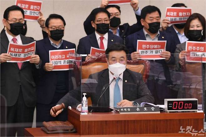 윤호중 국회 법제사법위원장이 8일 서울 여의도 국회에서 열린 법제사법위원회 전체회의에서 상법 일부개정법률안을 통과시키려하자 국민의힘 주호영 원내대표를 비롯한 의원들이 "독재로 흥한 자 독재로 망한다" 구호를 외치며 항의하고 있다. 윤창원기자