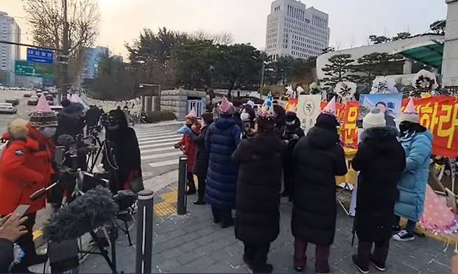 일부 보수단체 시민들이 18일 대검찰청 앞에서 고깔을 쓰고 윤석열 검찰총장 환갑 기념으로 시민들에게 떡을 돌리고 있다. 유튜브 캡처