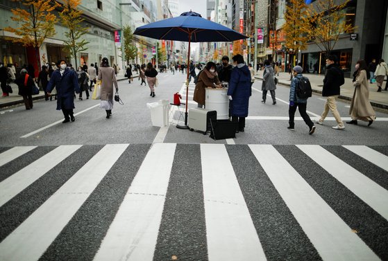지난 16일 일본 도쿄의 긴자 거리에서 행인들이 손소독제를 이용하고 있다. [로이터=연합뉴스]