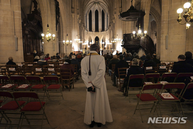 [파리=AP/뉴시스]크리스마스 이브인 24일(현지시간) 프랑스 파리의 생 제르맹 록세루아 교회에서 신도들이 예배를 드리고 있다. 신종 코로나바이러스 감염증(코로나19) 감염 예방을 위해 거리를 두고 앉아있다.